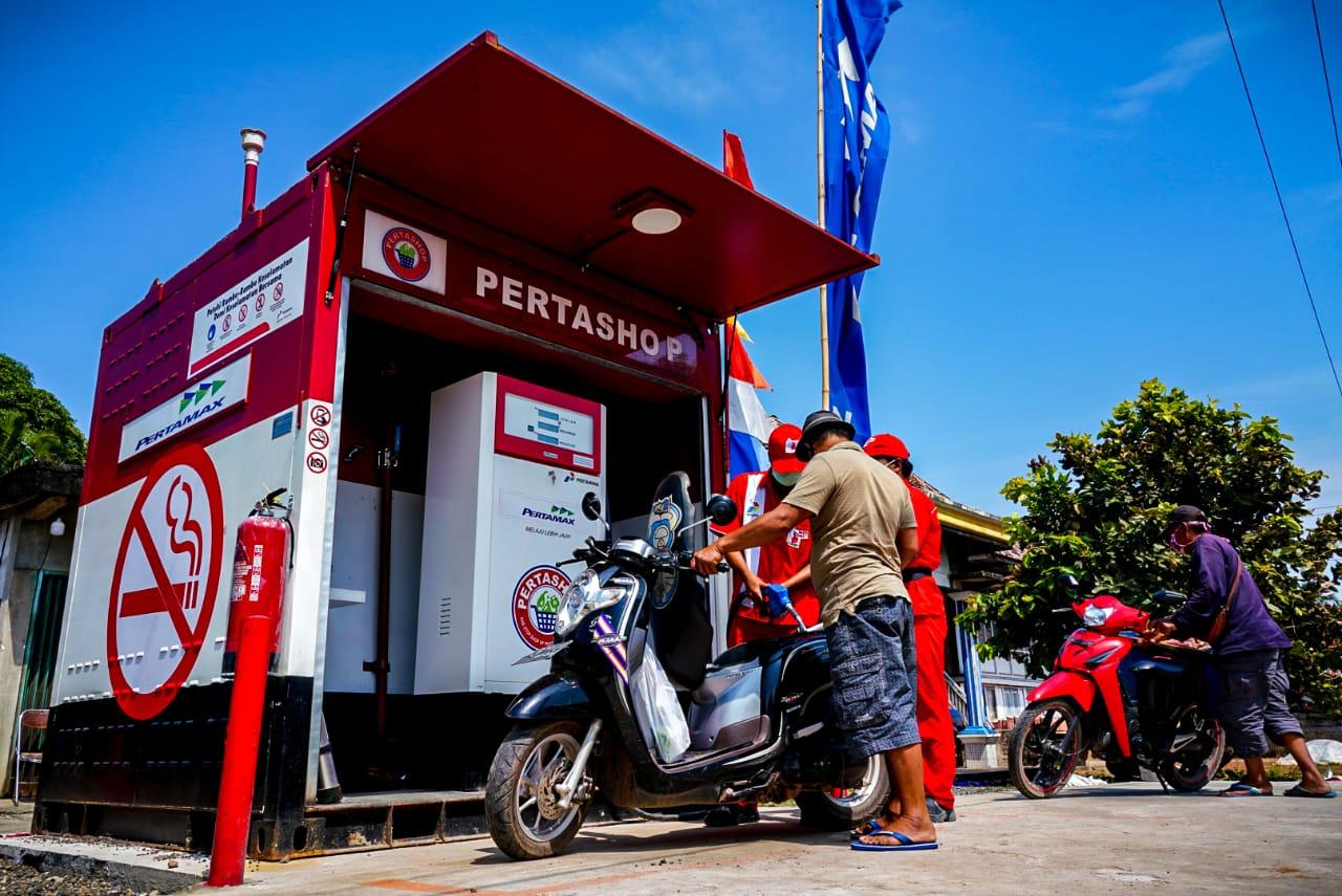 A man walks next to a mini gas station in Balikpapan, East Kalimantan on August 18, 2022. (Photo by ADEK BERRY / AFP)